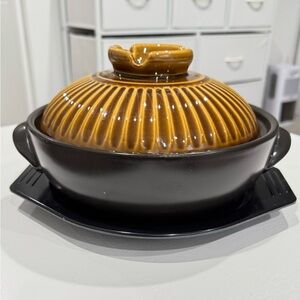 Japanese ceramic pot with lid and handle for cooking in the kitchen.